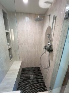 walkin shower gray tile with black tile floor